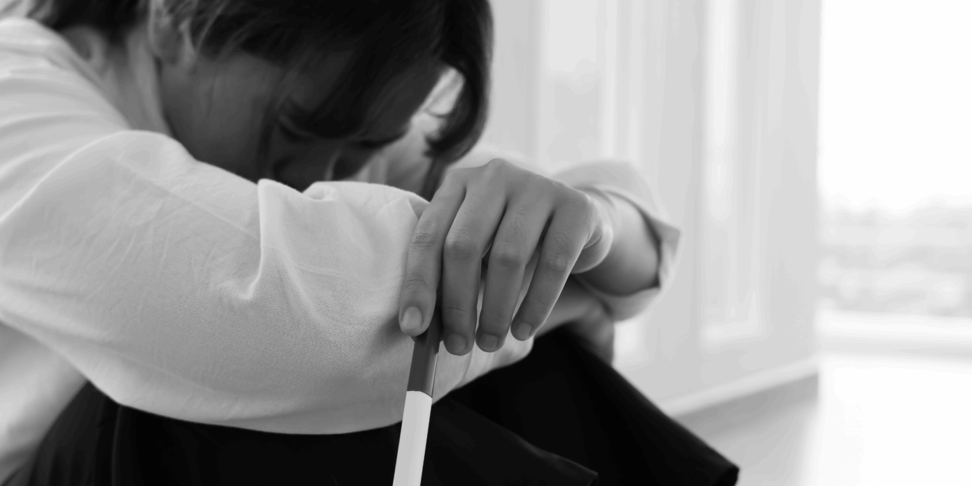 Image of woman with her arms wrapped around her legs and head in her knees.