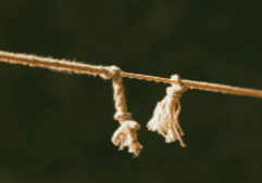 Rope pulled taut which is fraying and holding on by one thread.