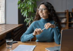 Woman sat at desk looking relaxed while looking out a window.