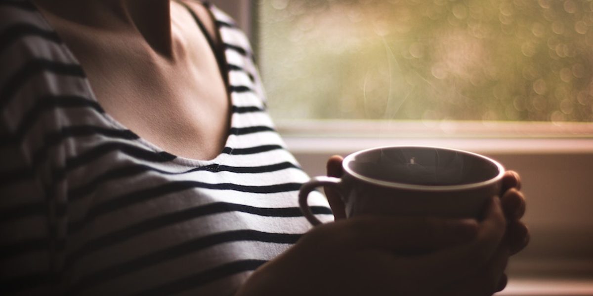 Woman with mug: Why self care is a priority