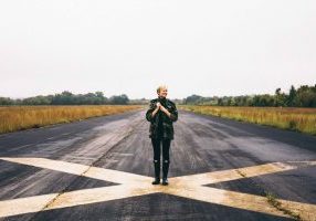 Woman standing on big painted cross: how to handle your inner critic